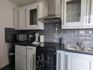 海维康Conegra Road by Wycombe Apartments的厨房配有白色橱柜和黑色家电