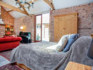 SpaxtonParish Land Barn的一间卧室设有一张床和砖墙
