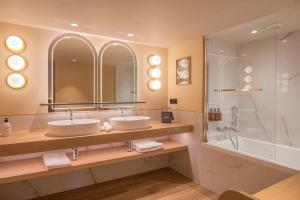 波尔多Hôtel Burdigala by Inwood Hotels的一间带两个盥洗盆和淋浴的浴室