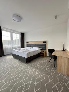 MedzilaborceTypton hotel&spa的一间卧室配有一张床、一张桌子和一张桌子