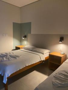 卡夸尔Hotel Darcisbel的一间卧室设有两张床和两个床头柜