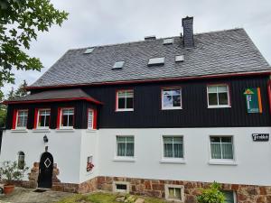 Kurort BärenburgHaus Fernblick的一间大型黑白色房屋,设有红色窗户