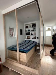 哥本哈根Unique boathouse.的一间设有一张床铺的卧室,位于一个带镜子的房间
