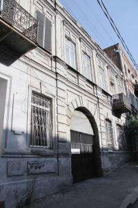 第比利斯Angels Roof Vera - boutique apartment. Wine Factory的街道上一座带拱门的古老建筑
