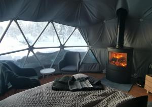 VuontisjärviArctic Nature Experience Glamping的一间设有一张床的客房,帐篷内设有一个壁炉