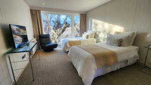 百内三塔拉戈格瑞酒店的酒店客房设有两张床和窗户。