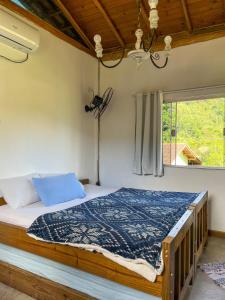 帕拉蒂Flat aconchegante próximo à Trindade e Paraty的一间卧室配有一张带蓝色棉被的床和窗户。