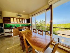 阿约拉港Blue Heron Galápagos Villa的一间带木桌和大窗户的用餐室