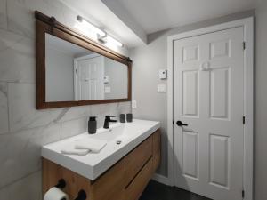 OrfordChalet Détente Orford的浴室设有白色水槽和镜子