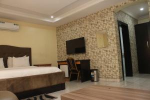 拉各斯MITOS LUXURY SUITES -Somosu的一间酒店客房,配有一张床和一台墙上的电视