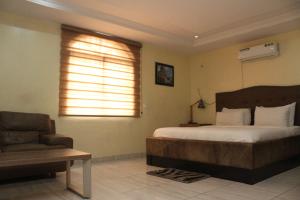 拉各斯MITOS LUXURY SUITES -Somosu的一间卧室配有一张床、一张沙发和一个窗口
