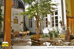 弗伦斯堡Das Gelbe Haus - Drei besondere Ferienwohnungen的庭院配有桌椅和一棵树
