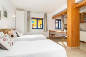 阿尔布费拉罗西奥海公寓式酒店的酒店客房配有两张床和一张书桌
