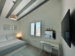 塞拉尔朱斯Villa Noga Rooms的一间卧室配有一张床、一张书桌和一台电视。