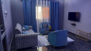巴马科Appartement Bamako ACI 2000的客厅配有两把椅子和电视