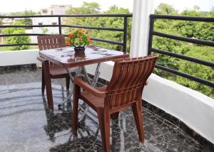巴马科Appartement Bamako ACI 2000的鲜花阳台的一张桌子和两把椅子