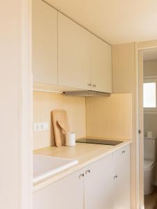 卡达克斯wecamp Cadaqués的厨房配有白色橱柜和台面