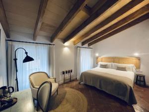 马翁Hotel Casa Miranda - Adults Only的一间卧室配有一张大床和一把椅子