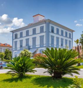 马里纳迪马萨缇雷诺酒店的一座白色的大建筑,前面有棕榈树