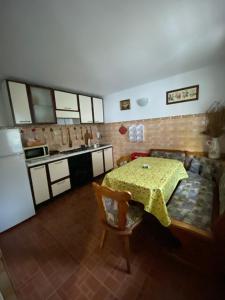 伯伊莱海尔库拉内Casa Aura的一间带桌子和沙发的厨房以及一间配有冰箱的厨房