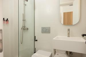 利瓦迪奥NŌSTOS Serifos的带淋浴、盥洗盆和镜子的浴室