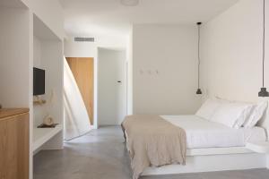 利瓦迪奥NŌSTOS Serifos的一间白色卧室,配有床和电视