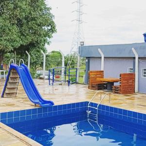 帕苏斯Chacara Tropicalia的一个带滑梯和游乐场的游泳池