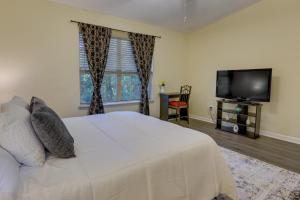 塔拉哈西Tallahassee Townhome with Patio Near FSU Campus!的卧室配有白色的床和平面电视。
