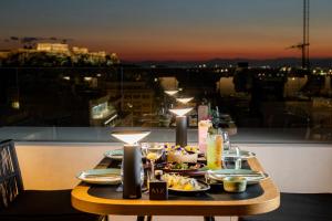 雅典Academias Hotel, Autograph Collection的阳台上摆放着食物盘的桌子