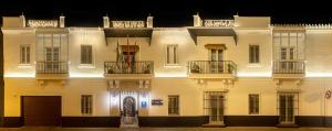 桑卢卡尔-德巴拉梅达Albariza Hotel Boutique的一座大型白色建筑,晚上设有阳台