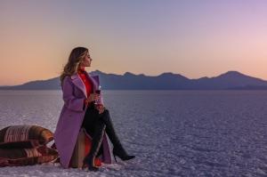 Colchani萨尔露娜萨拉达酒店的坐在沙漠中的身穿紫色外衣的女人