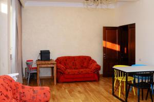 埃里温Kenut Hostel的客厅配有红色的沙发和桌子