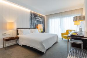 里斯本萨尔达尼亚酒店的卧室配有一张白色大床和一张书桌