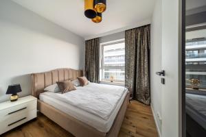 比亚韦斯托克ResiNest Apartamenty Jurowiecka J11的一间卧室设有一张床和一个窗口