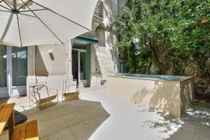 蒙彼利埃NOCNOC - Le Terrazzo - Petite piscine et jardin en ville的一个带遮阳伞和椅子的庭院和一个游泳池
