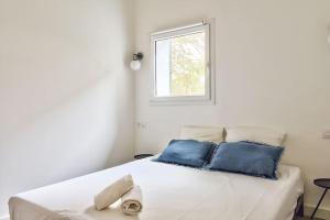 蒙彼利埃NOCNOC - Le Terrazzo - Petite piscine et jardin en ville的一张带蓝色枕头的白色床和窗户