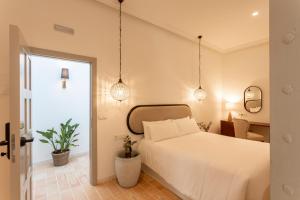 桑卢卡尔-德巴拉梅达Albariza Hotel Boutique的一间设有白色床和两盆植物的卧室