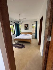 布韦朱Maracuja villa Zanzibar的一间卧室设有一张床和两个窗户。