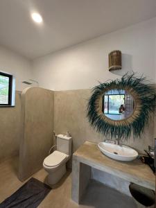 布韦朱Maracuja villa Zanzibar的一间带水槽、卫生间和镜子的浴室