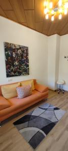 伊布斯河畔魏德霍芬Gästezimmer & Apartment Mayrhofer的客厅配有沙发和墙上的绘画
