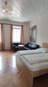 伊布斯河畔魏德霍芬Gästezimmer & Apartment Mayrhofer的一间卧室配有一张大床和一张沙发