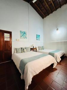 蒙波斯Casa Isabelita的白色墙壁客房的两张床