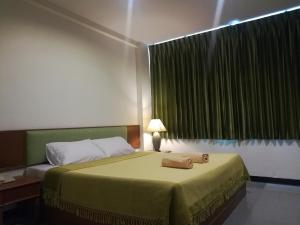 Ban Fang MinYMCA International Hotel Chiangrai的一间卧室配有一张床,床上有毛巾
