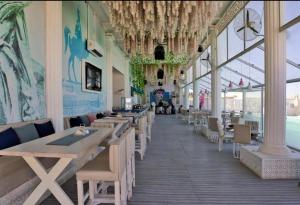 赫尔格达SELENA BAY RESORT HURGHADa的餐厅设有木桌、椅子和窗户。