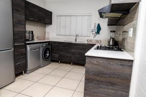 安特卫普Fullmoon Two Bed Apartment的厨房配有木制橱柜、洗衣机和烘干机