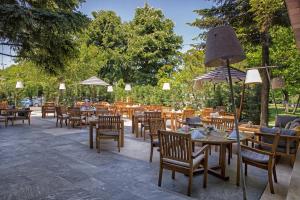 布加勒斯特布加勒斯特皇冠假日酒店的一间带桌椅和遮阳伞的餐厅