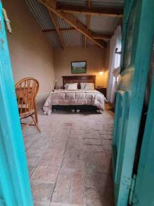 默西迪丝Casa de campo的一间卧室,卧室内配有一张床和一把椅子