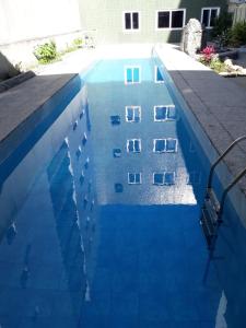 马卡埃Hotel Du Lac Macaé的大楼前的蓝色海水游泳池