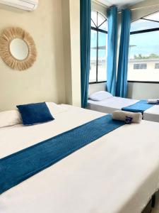 曼塔Reef Hostel Manta的配有两张床铺的蓝色窗帘和镜子