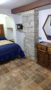 瓜纳华托Hotel Magdalena Colonial的一间卧室设有一张床和石墙